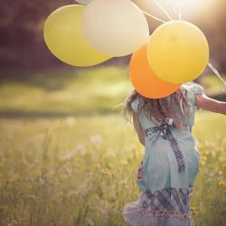 Das Bild zeigt ein Mädchen mit Luftballons