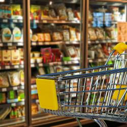 Einkaufswagen vor Supermarktregalen