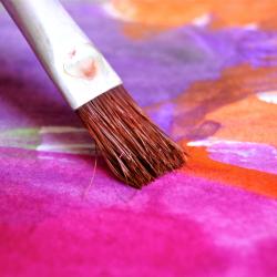 Pinsel malt mit violetter Farbe