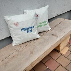 Zwei Kissen auf einer Holzbank