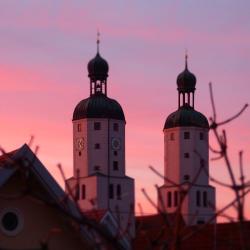 Das Bild zeigt die Wemdinger Stadtpfarrkirche bei Sonnenuntergang. 