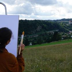 Auf dem Bild zu sehen eine Staffelei vor der Burg Harburg.