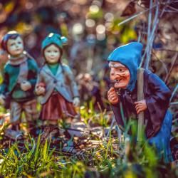 Tonfiguren von Hänsel, Gretel und der Hexe im Gras