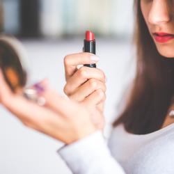 Eine Frau hält einen roten Lippenstift.