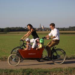 Das Bild zeigt eine Familie beim Radfahren.