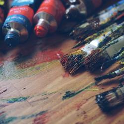 Das Bild zeigt Acrylfarben und Pinsel.