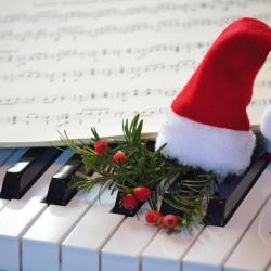 Eine kleine Weihnachtsmütze auf einem Klavier.