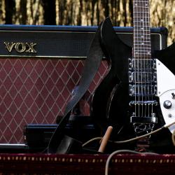 Eine schwarze E-Gitarre mit Verstärker.