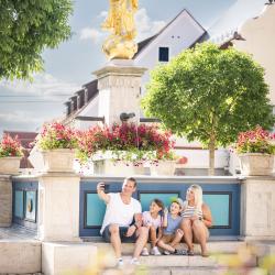 Menschen sitzen vor dem Mangoldbrunnen in Wemding