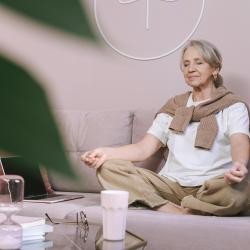 Frau meditiert auf dem Sofa